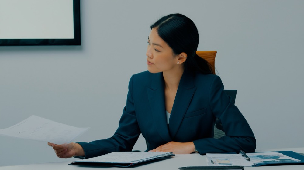 Two real estate professionals reviewing compliance documents at a desk